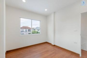 Empty bedroom with wooden floor and window