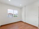 Empty bedroom with wooden floor and window