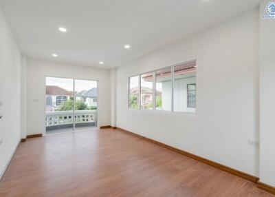 Spacious living room with large windows and wooden flooring