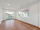 Spacious living room with large windows and wooden flooring