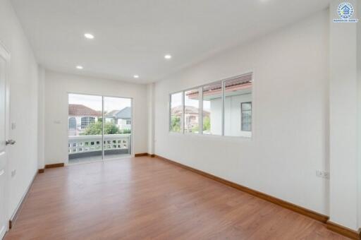 Spacious living room with large windows and wooden flooring