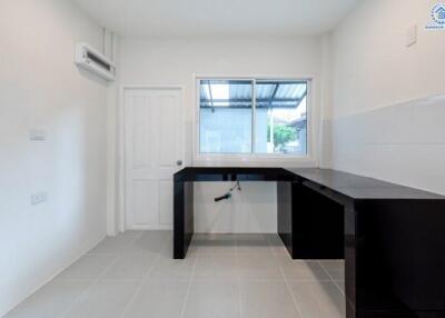 Minimalist kitchen with dark countertops and neutral walls