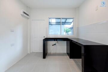 Minimalist kitchen with dark countertops and neutral walls