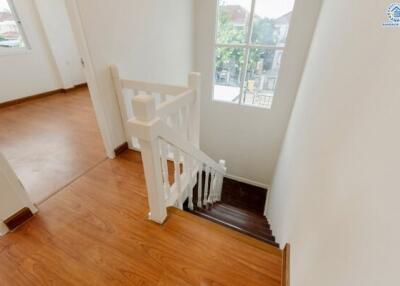 Bright staircase with wooden flooring and window view