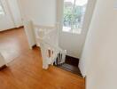 Bright staircase with wooden flooring and window view