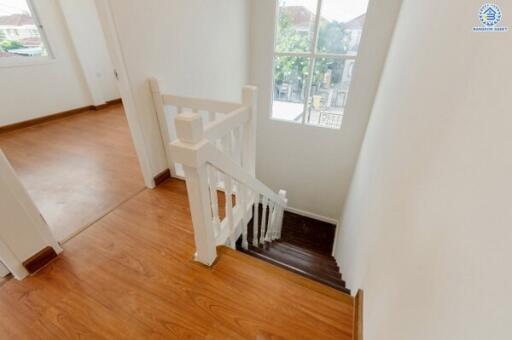 Bright staircase with wooden flooring and window view