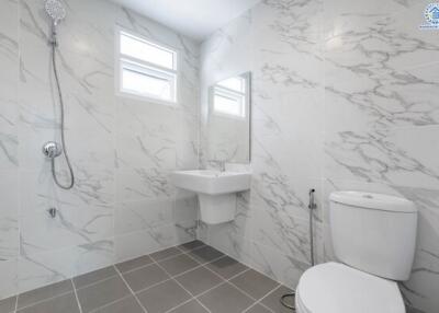 Modern bathroom with marble tile walls and grey tiled floor