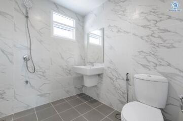 Modern bathroom with marble tile walls and grey tiled floor