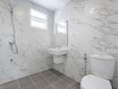 Modern bathroom with marble tile walls and grey tiled floor