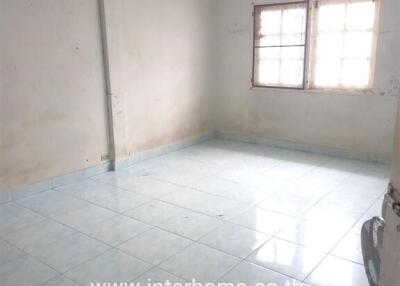 Empty room with tiled flooring and two windows