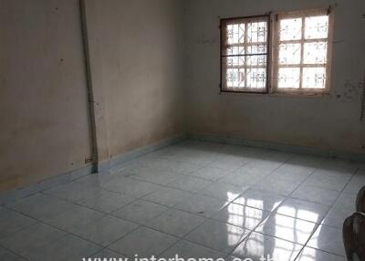 Empty room with tiled floor and barred windows