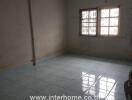 Empty room with tiled floor and barred windows