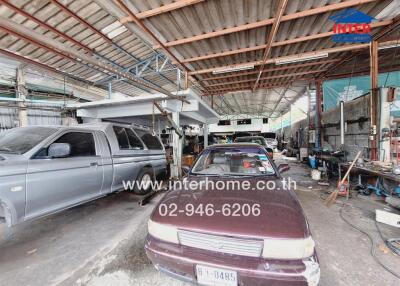 Photo of a large garage space with multiple vehicles and workshop tools