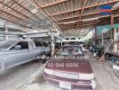 Photo of a large garage space with multiple vehicles and workshop tools