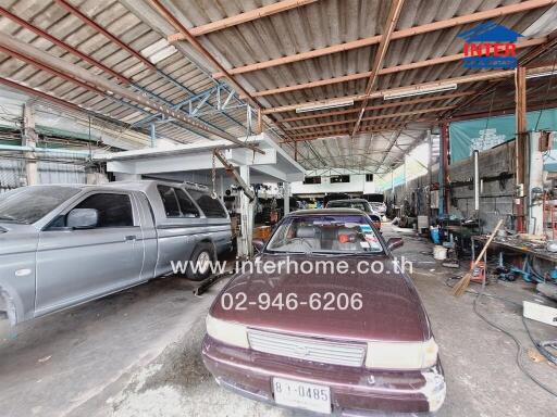 Photo of a large garage space with multiple vehicles and workshop tools