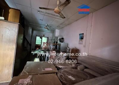 Interior view of a cluttered room with furniture and appliances