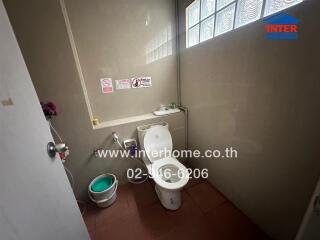 Small bathroom with a glass block window and toilet