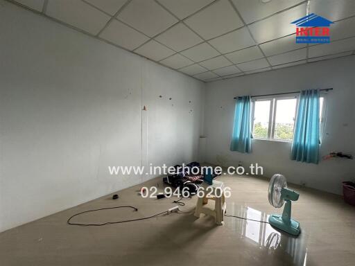 Empty bedroom with tiled floor, window, and ceiling fan