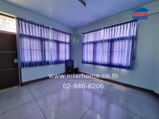 Spacious living room with large windows and blue curtains