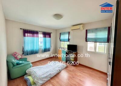 Bedroom with wooden floor, windows with curtains, air conditioning, TV, and bed