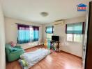 Bedroom with wooden floor, windows with curtains, air conditioning, TV, and bed