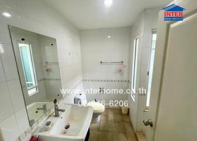 Modern white-tiled bathroom with shower and sink