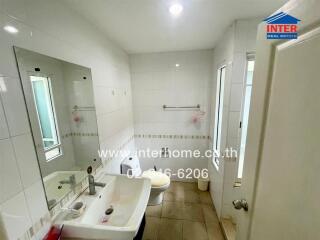 Modern white-tiled bathroom with shower and sink