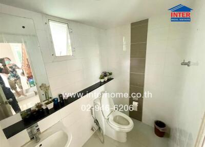 Modern bathroom with white tiling and a large mirror