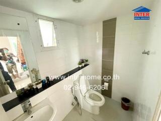 Modern bathroom with white tiling and a large mirror