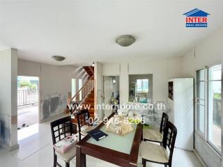 Modern dining area adjacent to a staircase and large windows