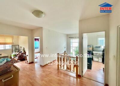 Spacious hallway in a home with wood flooring and access to various rooms.