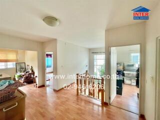 Spacious hallway in a home with wood flooring and access to various rooms.