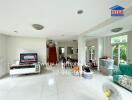 Spacious living room with white tiled flooring, a TV, and a green couch