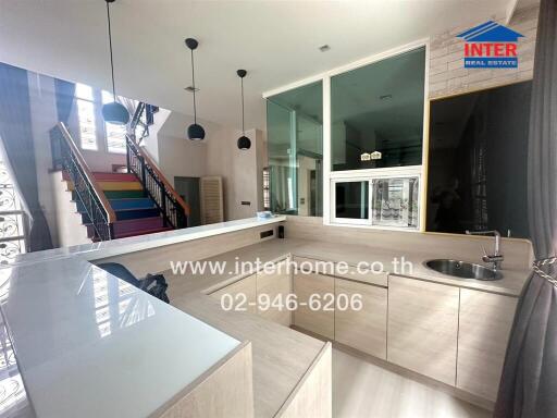 Modern kitchen with island counter and colorful staircase