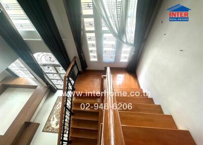 Well-lit wooden staircase with large windows