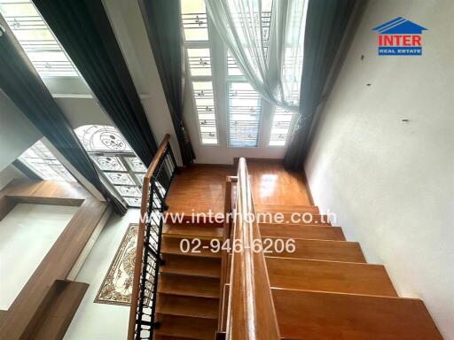 Well-lit wooden staircase with large windows