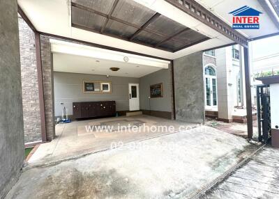 Covered garage area in front of the house with storage cabinets