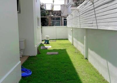 Small backyard with green lawn and utility items