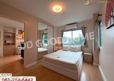 Modern bedroom with large window, mirror closet, and wood flooring