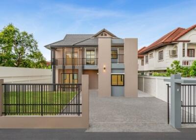 Modern two-story house exterior with gated driveway