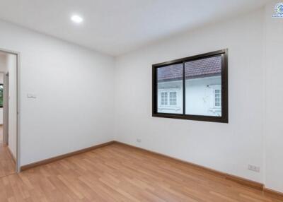 Empty bedroom with wooden floor and large window