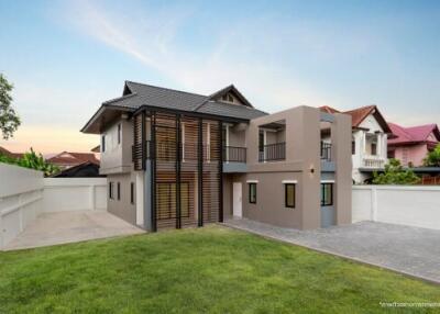 Modern two-story house with large windows and lawn