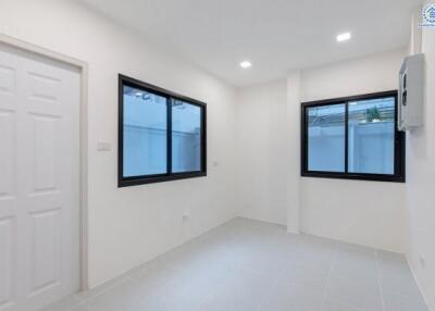 Clean, white-walled room with two windows and a closed door