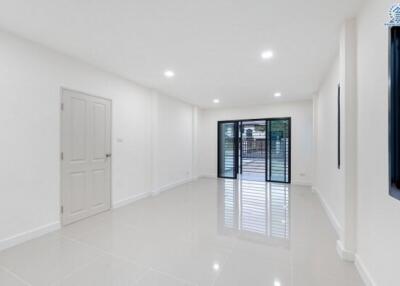 Spacious living room with large windows and tiled floors