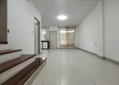 Spacious living room with tiled flooring and natural light