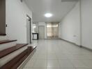 Spacious living room with tiled flooring and natural light