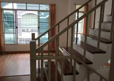 Staircase view in a bright living area with large windows