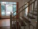 Staircase view in a bright living area with large windows