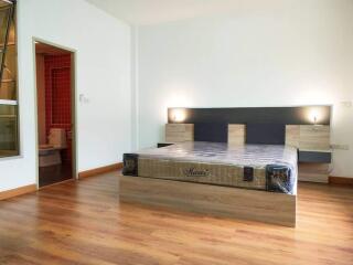 modern bedroom with wooden flooring and en-suite bathroom