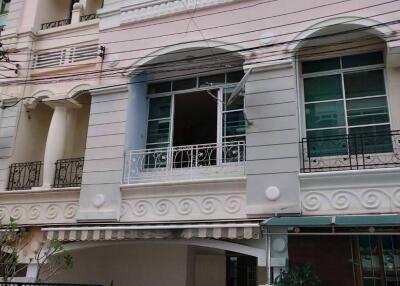 Front view of a multi-story residential building with gated entry and balconies